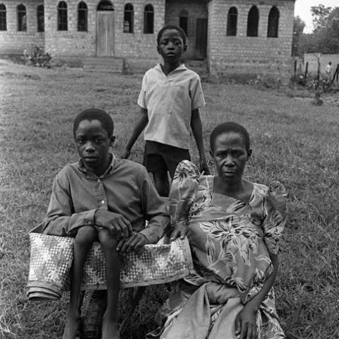 Three people in the front yard of a church.