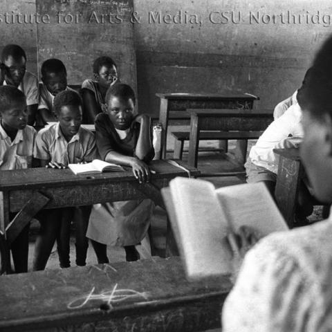 Students sitting on a desk in the classroom.