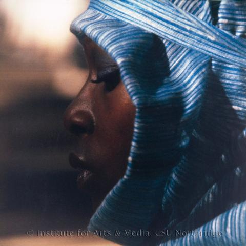 A black woman in a blue scarf wrapped around her head