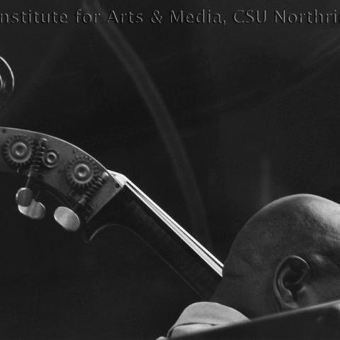 The head of a bald man and scroll of a stand-up bass