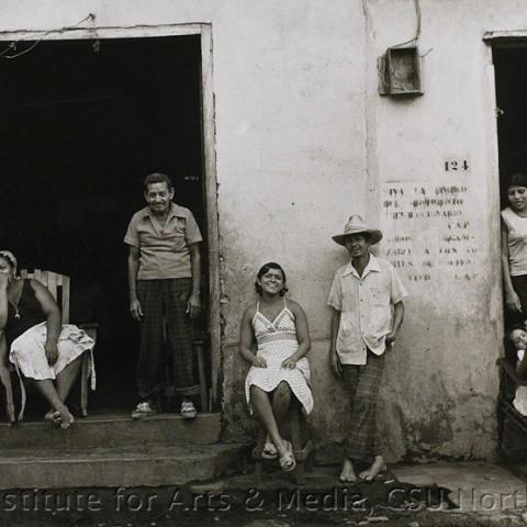 Six people taking leisure in front of a storefront