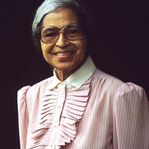 An elderly woman wearing a pink dress.