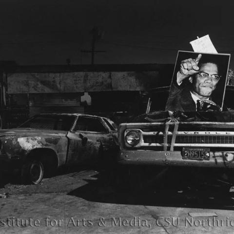 Old cars with a huge portrait on the windshield.