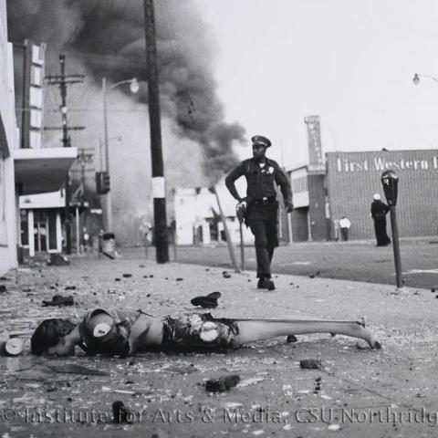 A destroyed mannequin and a policeman walking by.