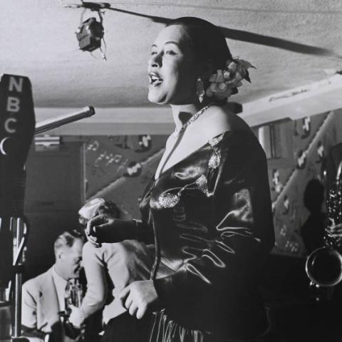 A woman singing in front of the microphone.