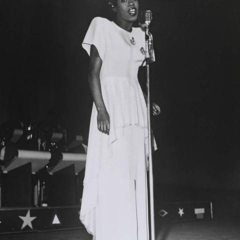 A woman performing in front of a microphone.