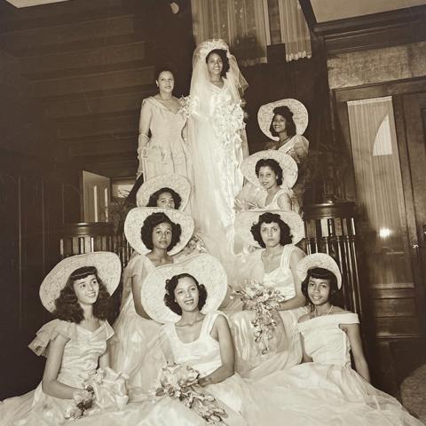 Bride with bridesmaids in wedding attire grouped on staircase