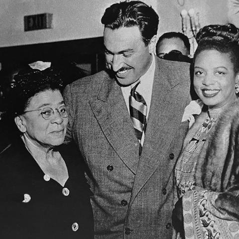 Two women and a man in candid photo at an event