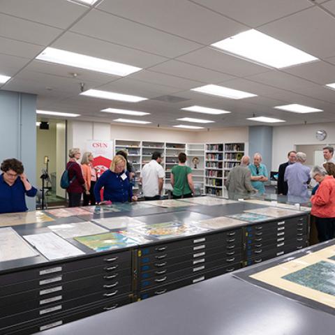 Attendees browse maps and other materials at the Grand Opening of the Map Collection at the Oviatt Library