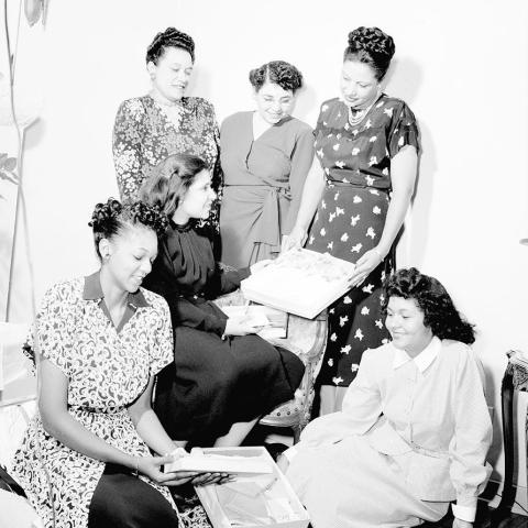 Image of Haroldine Browning opening gifts at a baby shower. 