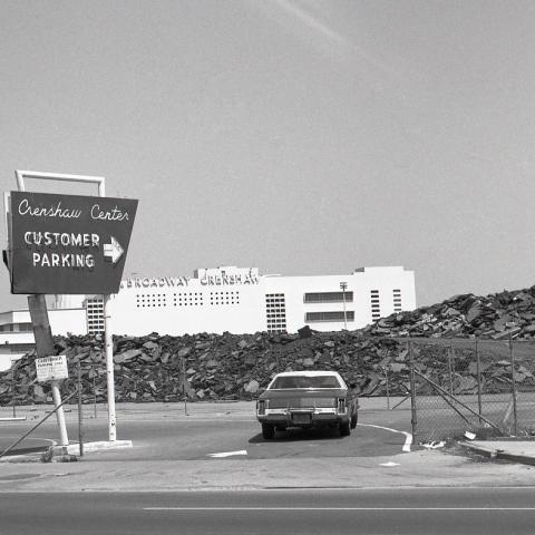 Exterior view of the former Crenshaw Center, with a sign for customer parking and the Broadway department store building still intact, circa 1980-1988. Roland Charles Collection..