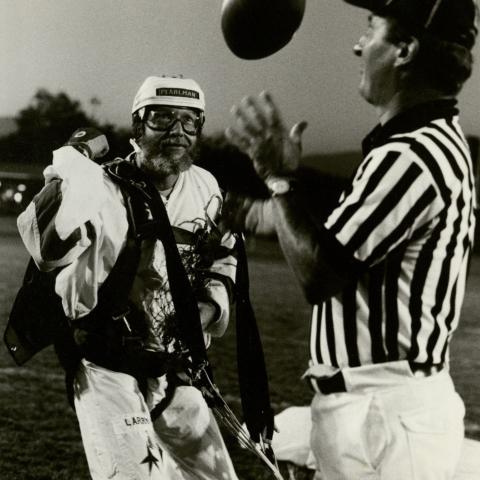 Skydiver Larry Pearlman hands game ball to referee prior to kickoff of home opener, 1981. University Archives Photograph Collection