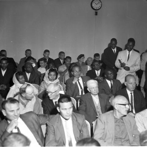 Malcolm X seated in the courtroom audience, Harry Adams Photograph Collection