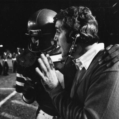 Player and coach discuss upcoming play, ca. 1982. University Archives Photograph Collection