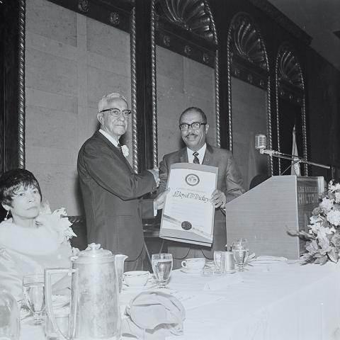 Mr. Llyod Dickie receiving a certificate at his retirement party, 1969, Jack Davis Photograph Collection, Box 17 Folder 6.