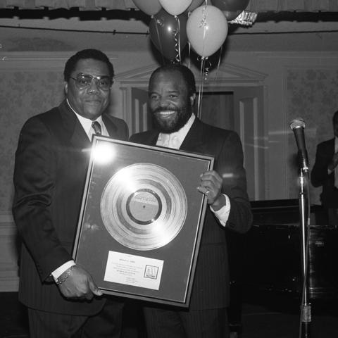 Robert (Bob) G. Jones (left) receives a gold record from Berry (Mr. Motown), Gordy, Chairman of the Board of Motown Record Corporation during a Black Public Relations Society of Southern California event. Guy Crowder Collection