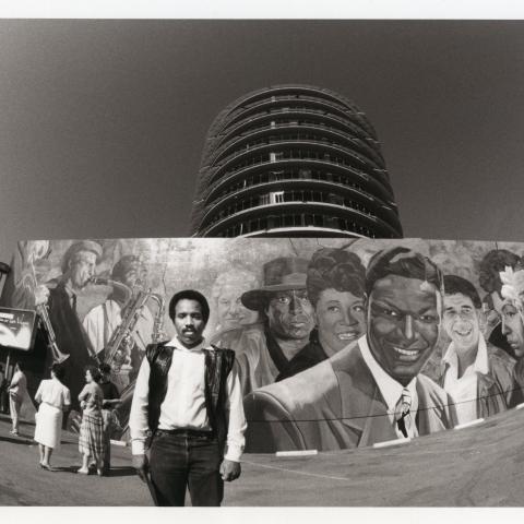 Artist Richard Wyatt, Jr with his mural Hollywood Jazz: 1945-1972 at the Captial Records building, 1990, Roland Charles Collection