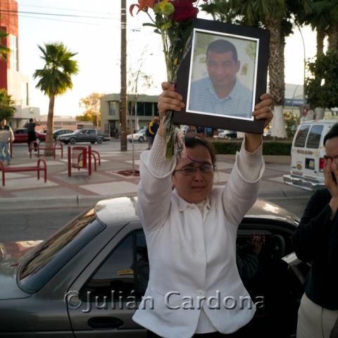Blanca Martinez raises the photograph of her murdered husband, Armando Rodriguez, Juárez, 2008