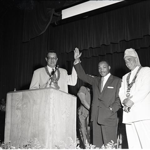 Rev. Dr. Martin Luther King Jr. posing at a lectern with Hobson R. Reynolds and others, Los Angeles. August 27, 1956, Harry Adams, 93.01.HA.B3.N45.392