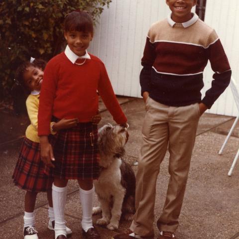 A photograph of three children and a dog