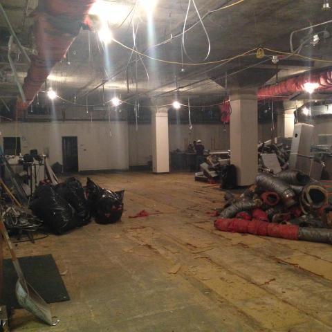Demolition begins behind the temporary wall.