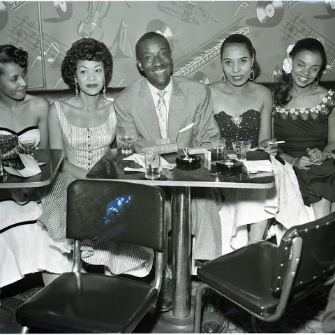 Lorraine Adams (left), Elihu “Black Dot” McGee (center) and his wife Elizabeth (right of McGee), and others at the Tiffany Club. From the Harry Adams Collection. 