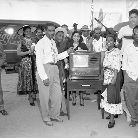 Cavalcade of Jazz promoter Leon Heflin Sr. standing next to television prizewinner. From the Charles Williams Collection. 