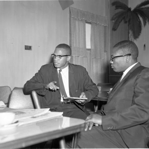 Malcolm X and Minister John Shabazz of Mosque No. 27 sitting at a table, Harry Adams Photograph Collection
