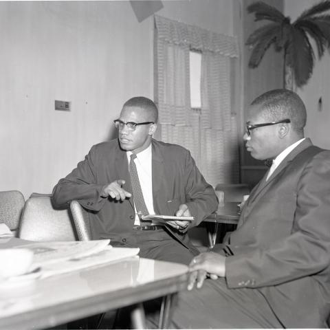Malcolm X (left) sits at a table with John Shabazz (Abdul Allah Muhammad), minister of Nation of Islam's Temple 27, May 5, 1962. Harry Adams Collection, 93.01.HA.B1.N45.191