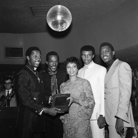 The Temptations with Gertrude Gipson (from the L.A. Sentinel) receiving a plaque for being the ""Nations Number One." Left to right: Melvin Franklin, Eddie Kendricks, Dennis Edwards, Otis Williams. Harry Adams Collection