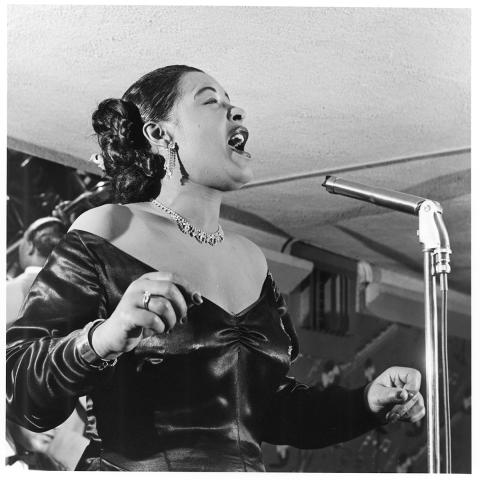 Billie Holiday (side view) singing at the Tiffany Club with a bass player, Los Angeles, 1952.