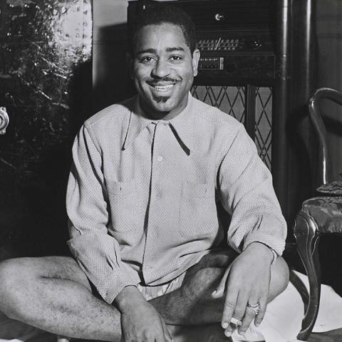 Trumpeter Dizzy Gillespie sitting on the floor in his hotel room, Detroit, 1947.