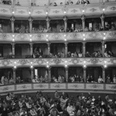 Interior of opera house, with audience in balcony and floor levels