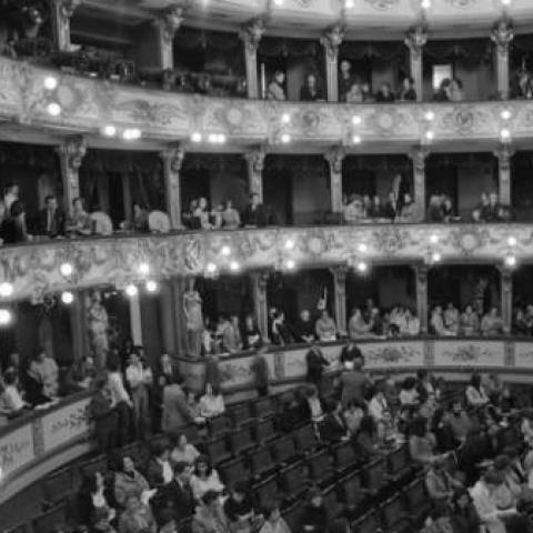 Interior of opera house, with audience in balcony and floor levels