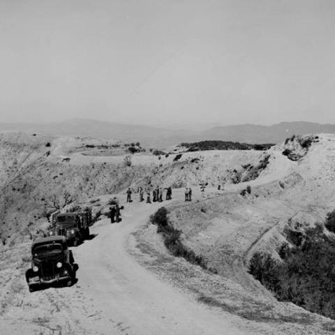 A group surveys land damaged by a brush fire near Burbank, ca. 1930s-1950s, BUR02