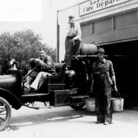 Members of the Volunteer Fire Department of Woodland Hills sitting on an engine in front of their fire house, 1936, CBHS15