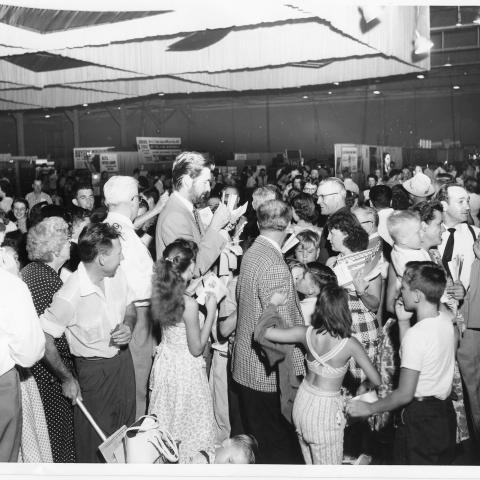 Actor Fess Parker signing autographs on the convention floor of the inaugural 1955 Union Products and Services Show