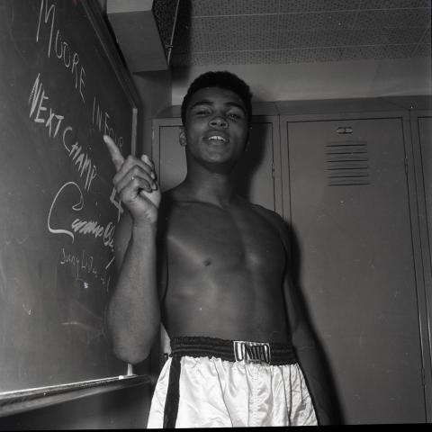 Cassius Clay pointing to a chalk board before the 1962 Archie Moore boxing match in Los Angeles,  93.01.HA.B4.N120.605.1