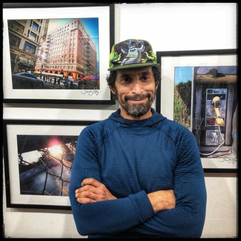 Workshop participant, Tim, standing in front of three of his photographs featured in the "How We See It" exhibit, 2020.