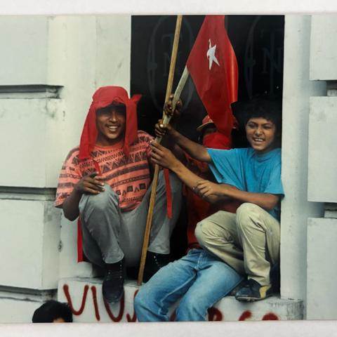 Image from collection selected by Student Assistant, Veronica: Salvadoran men sit posing with FMLN flags after the 1994 Chapultepec Peace Accords in San Salvador, El Salvador.