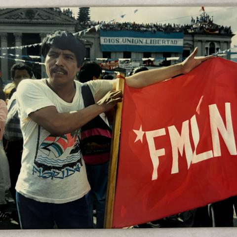 Image from collection selected by Student Assistant, Veronica: Salvadoran men show off their FMLN flag in front of the National Palace in San Salvador, El Salvador, 1994.