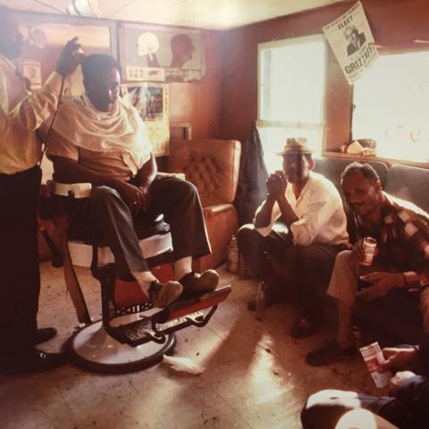 Johnny Bolden is cutting one of his best friend’s hair with Roland’s uncles Octave, Charlie, and Tiny (Charles) looking on while at Johnny’s Barbershop. 1979. TBC.RCH