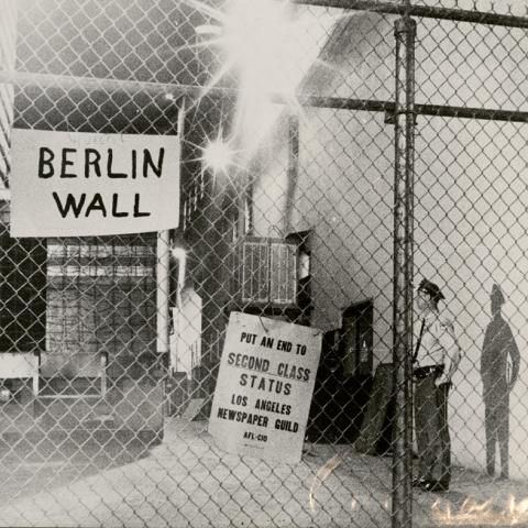 Chain link fence with sign that reads "Berlin Wall" during lockout