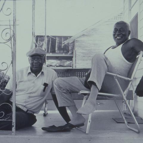 Two locals relax on the porch. TBC.RCH