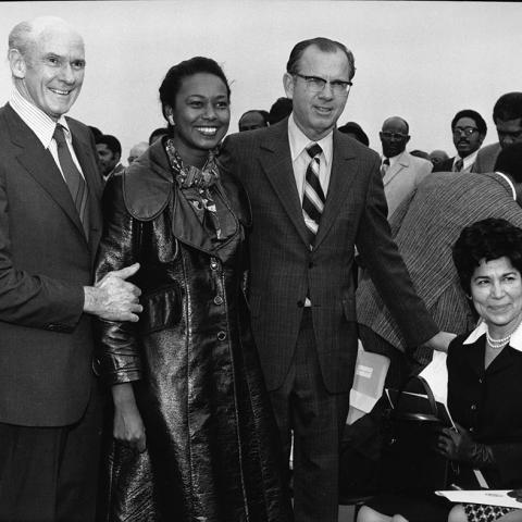 Senator Allan Cranston, Congresswoman Yvonne Brathwaite Burke, County Supervisor Kenneth Hahn, and an unidentified woman pose for a group portrait at an outdoor event. 1973. Digital ID: 91.01.GC.P.B1.24