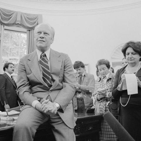 President Gerald Ford talks with reporters, including Helen Thomas, as White House Chief of Staff Richard Cheney looks on, during a press conference at the White House, Washington, D.C. September 30, 1976