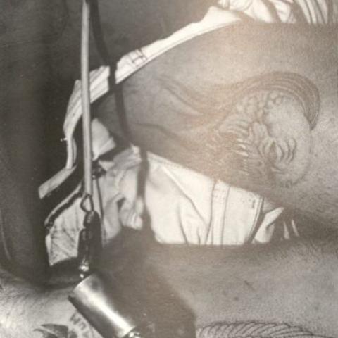 A tattoo artist working on an outline of a tattoo, in Customizing the Body: The Art and Culture of Tattooing, 1989