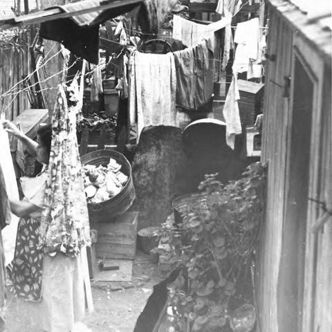 View of connected homes with hanging laundry.  This location is now occupied by William Mead Homes public housing project in Chinatown.
