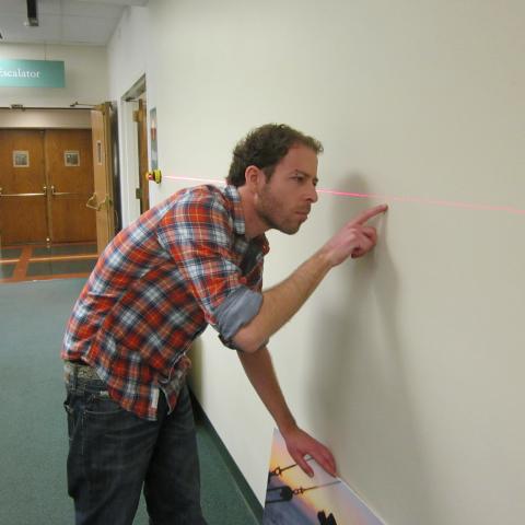 man looking closely at a wall