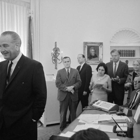 President Lyndon Johnson with the press at a news conference in the Oval Office. Helen Thomas at the rear with a pad and pen